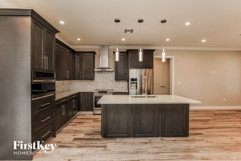 A modern kitchen with dark wood cabinets and a central island.