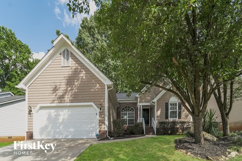 a house with a garage and a tree in front of it