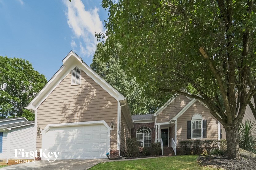a house with a garage and a tree in front of it