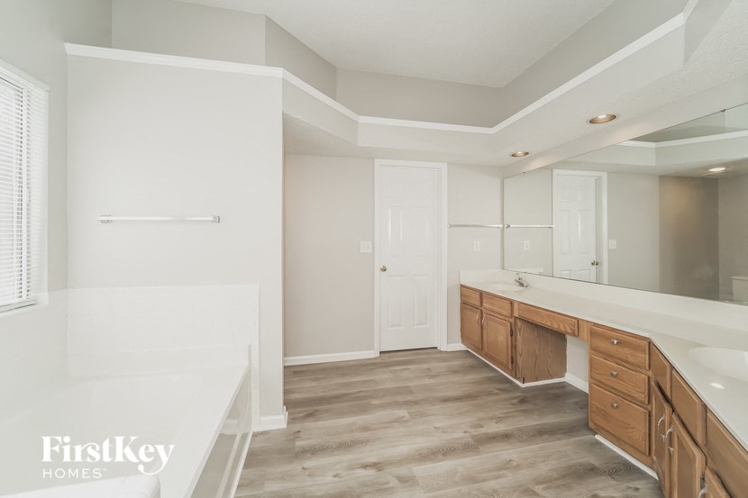 a bathroom with a large tub and a sink and a mirror