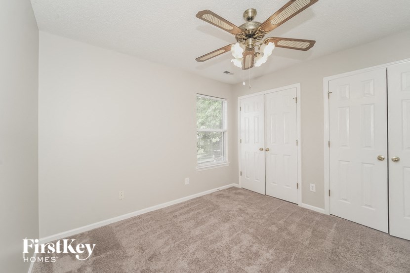 a bedroom with a ceiling fan and a closet