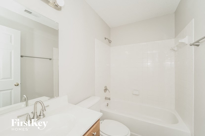 a white bathroom with a tub and a sink