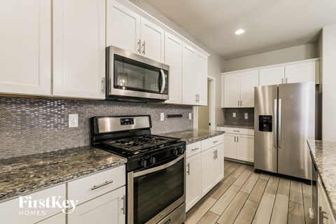 A kitchen with a stove top oven and a microwave above it.