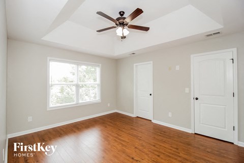 a living room with wood floors and a ceiling fan