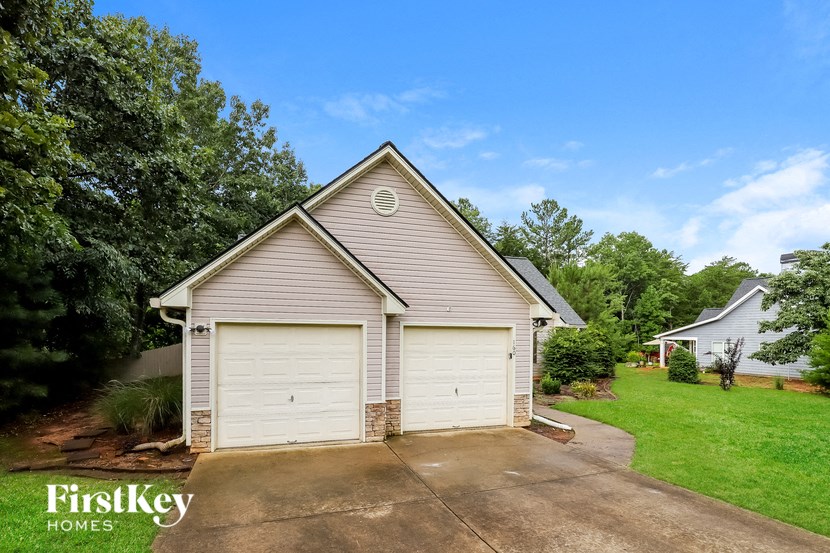 a garage with two white doors on the side of a house