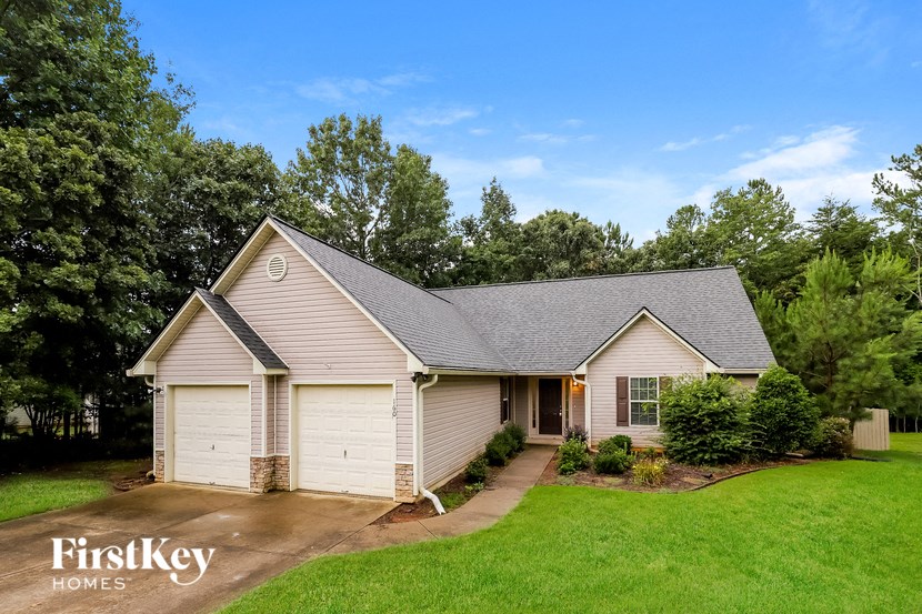 a small white house with a yard and a driveway
