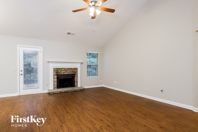 a living room with a fireplace and a ceiling fan