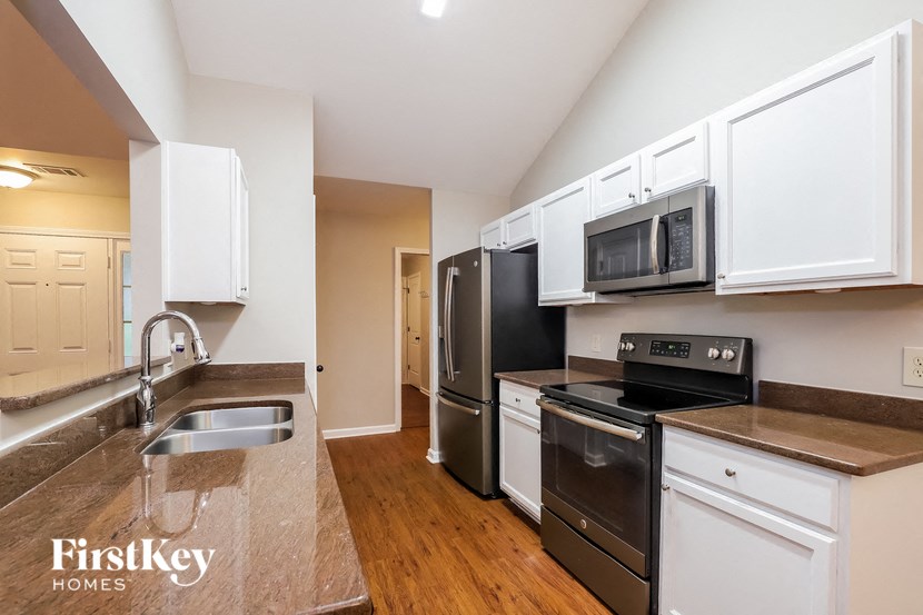 a kitchen with stainless steel appliances and white cabinets