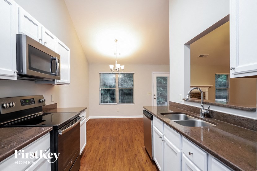 a kitchen with white cabinets and a sink and a microwave