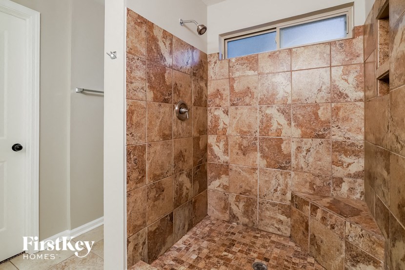 a tiled shower in a bathroom with a window