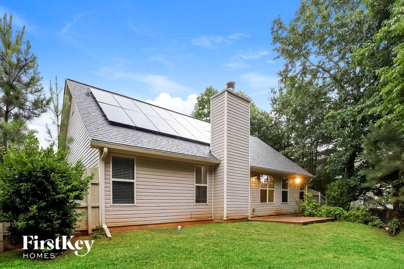 a small white house with solar panels on the roof