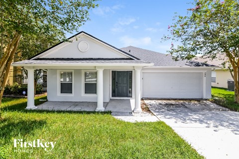 a small white house with a driveway and a garage door