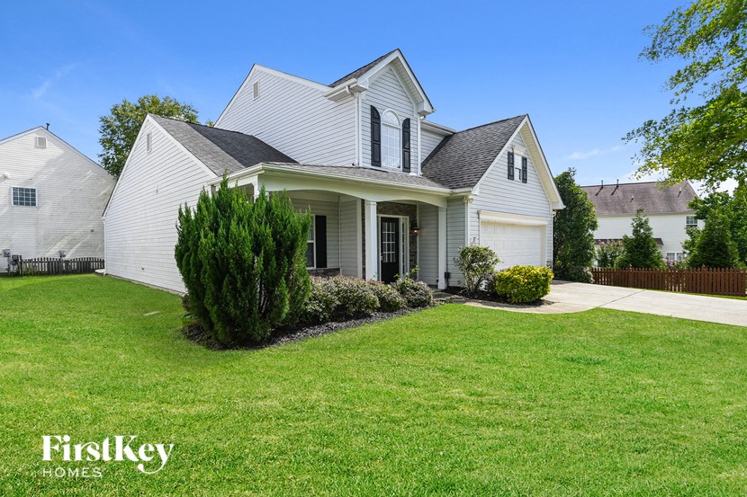 a white house with a yard and a green lawn