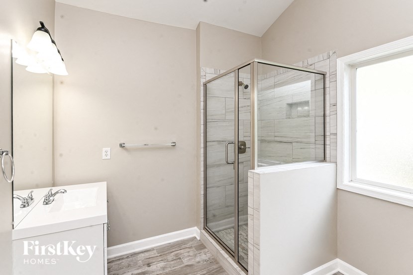 a white bathroom with a shower and a sink