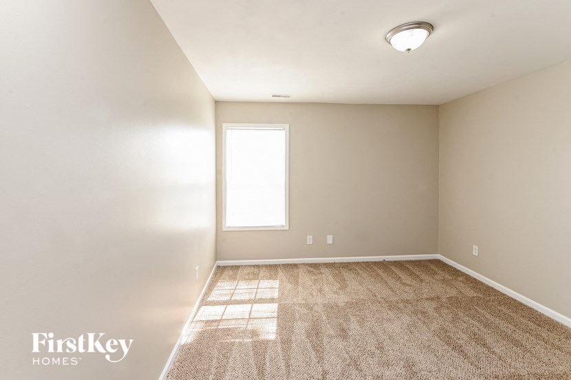 a empty room with a window and a carpet
