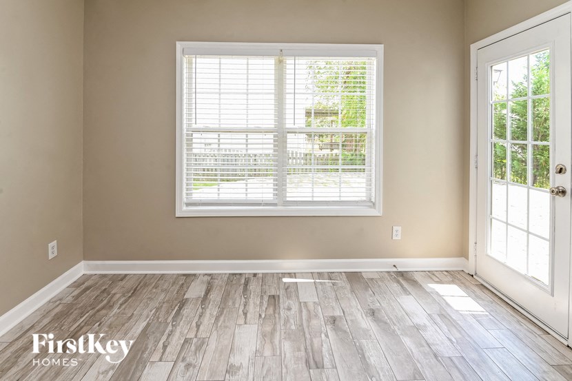a living room with a large window and wooden floors