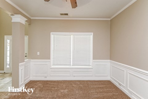 a dining room with white walls and a large window