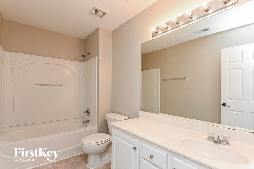 a bathroom with a toilet and a sink and a mirror
