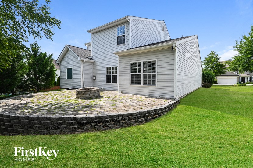 a stone patio in front of a white house