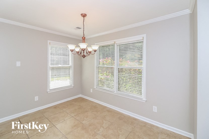 a dining room with two windows and a chandelier