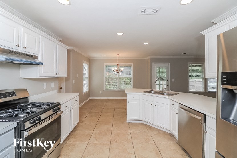 a large kitchen with white cabinets and stainless steel appliances