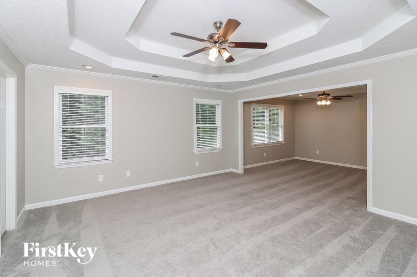 an empty living room with a ceiling fan