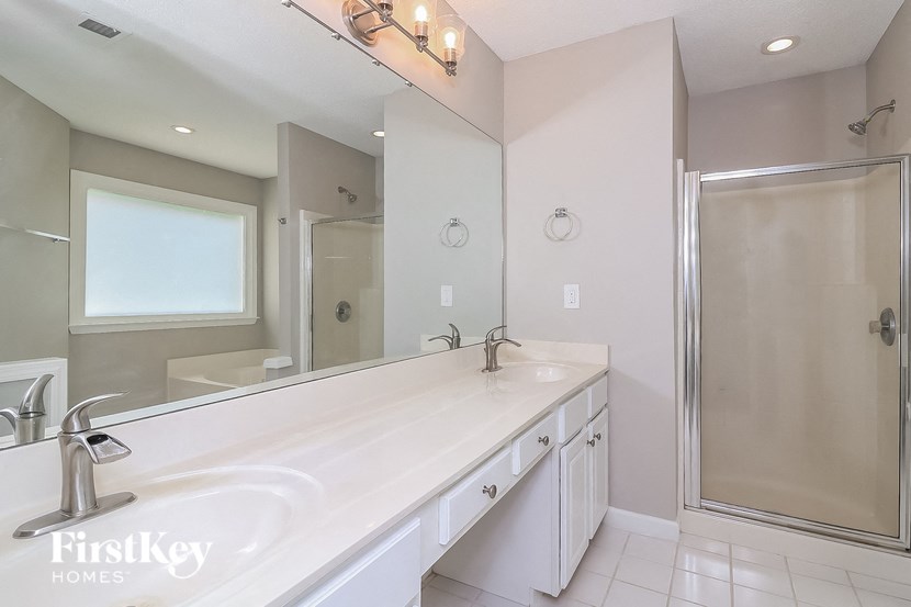 a bathroom with a large mirror and a sink and a shower
