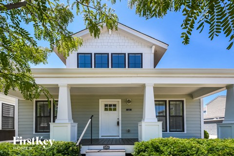 a white house with white pillars and a white front door
