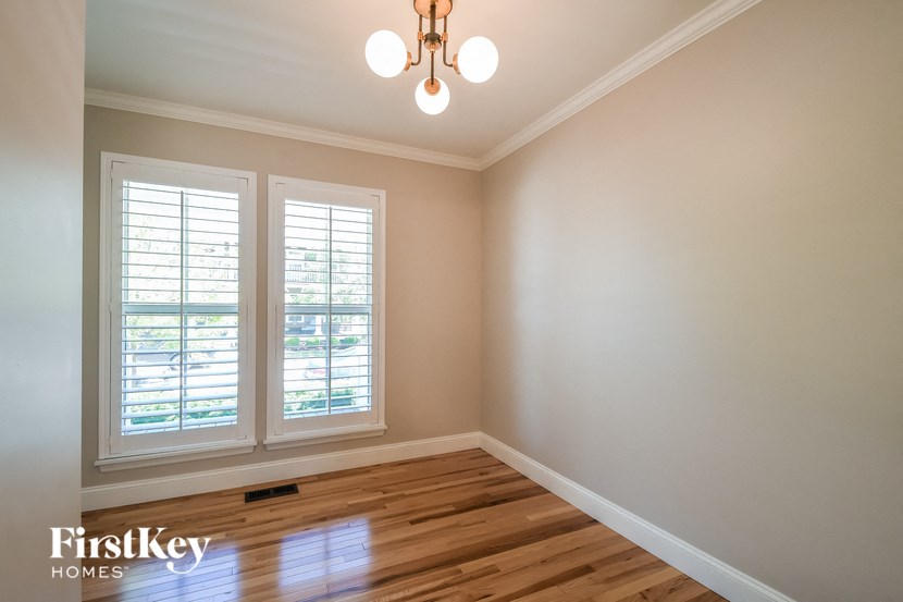 a empty room with two windows and a wooden floor