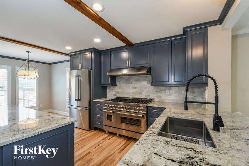 a kitchen with black cabinets and granite counter tops and a sink