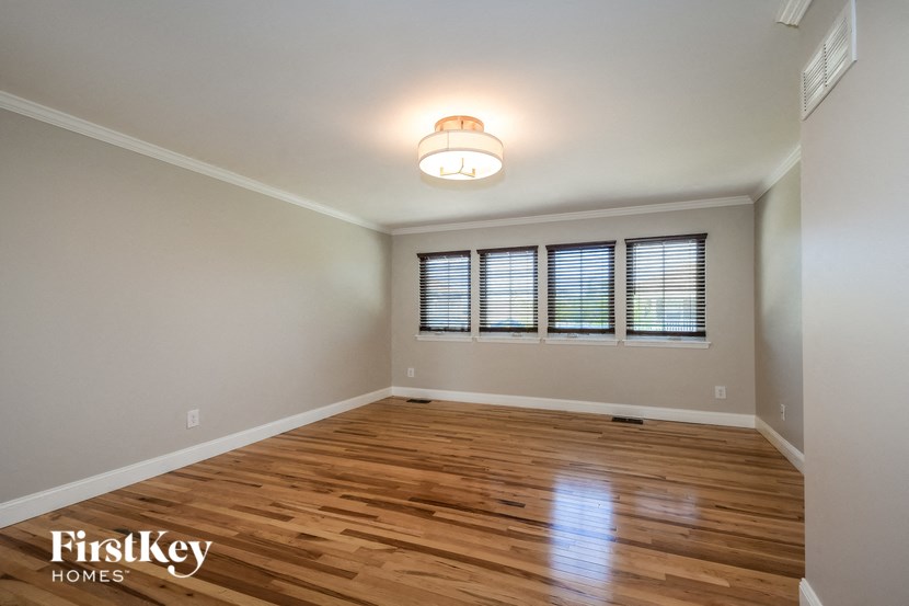 an empty living room with wood flooring and a window