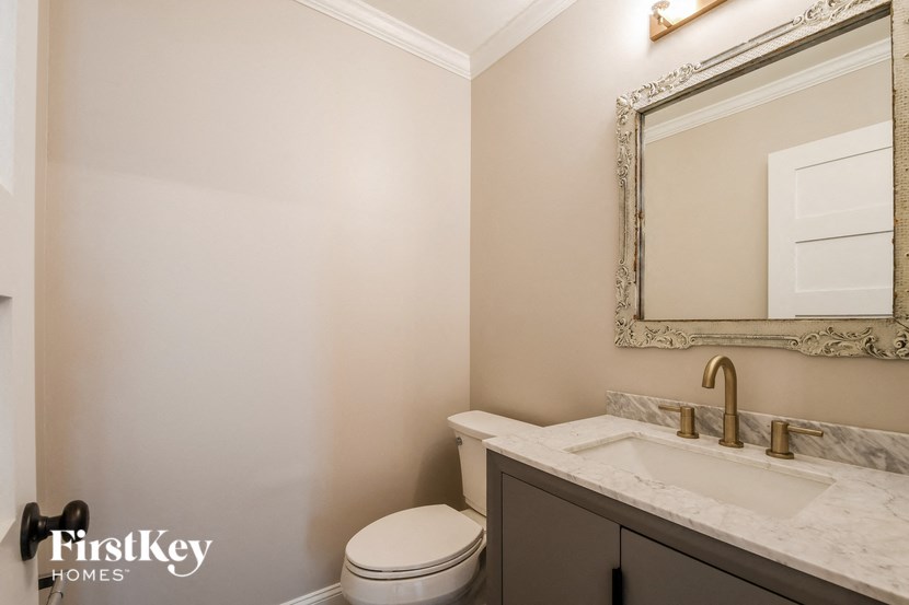 a bathroom with a toilet and a sink and a mirror