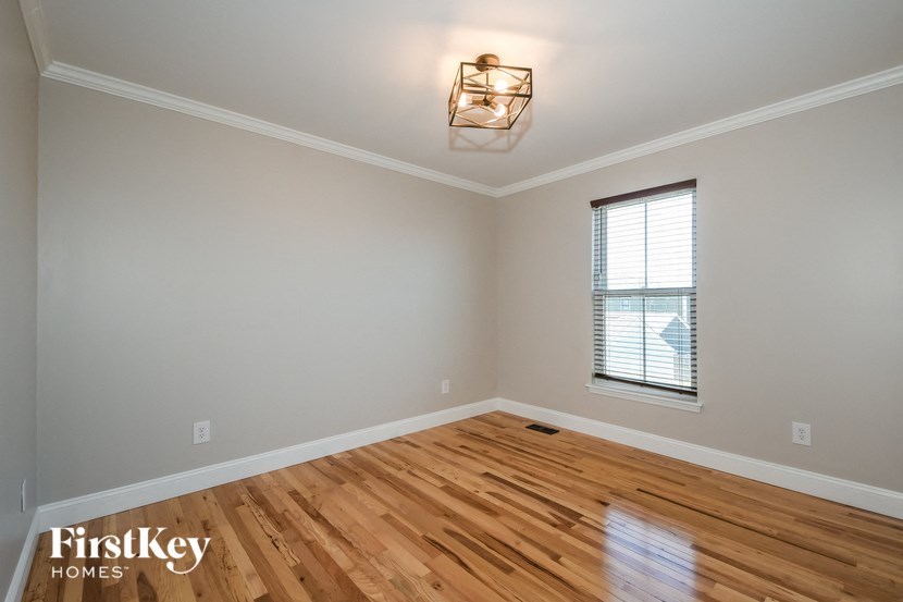 a living room with a wooden floor and a window