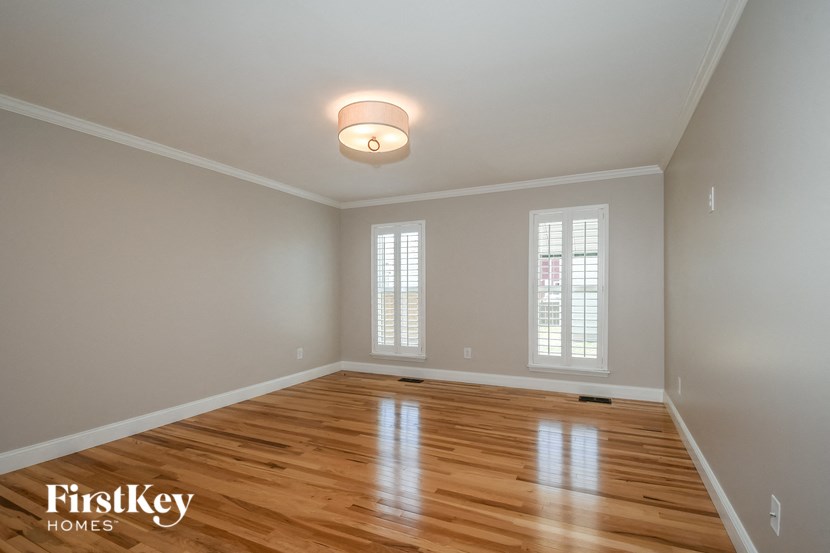 an empty living room with a hardwood floor and window