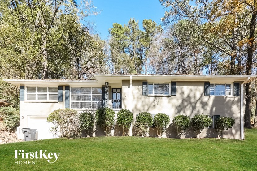 A white house with a green lawn in front of it.