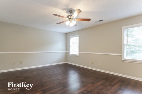 a living room with hardwood floors and a ceiling fan