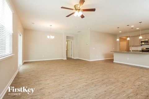 A spacious room with a ceiling fan and wooden flooring.