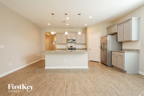 A kitchen with wooden floors and a white island.