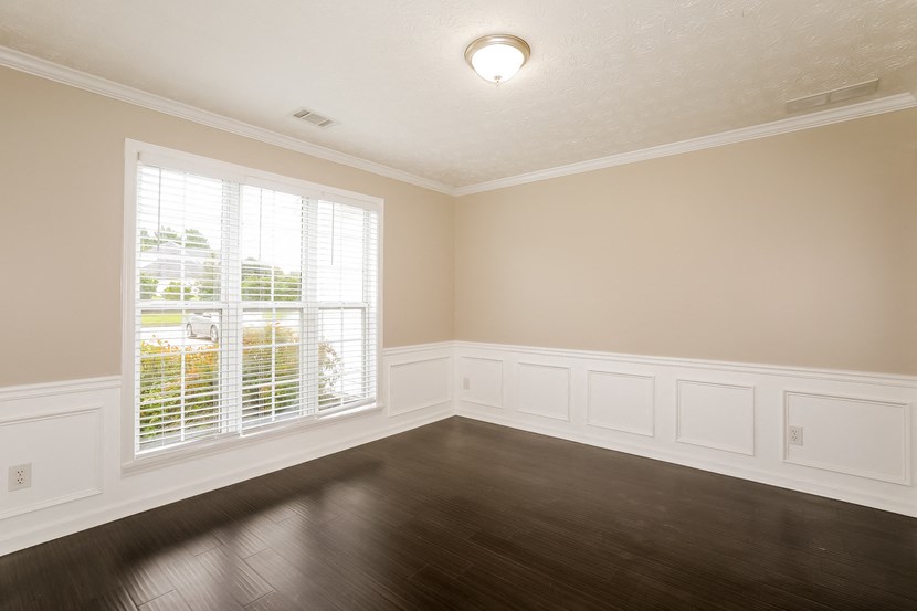 A room with a window and wooden floors.
