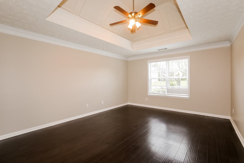 A room with a ceiling fan and a window.