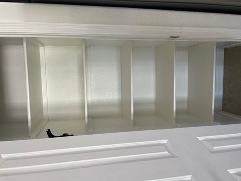 an empty closet with a black shoe on the floor