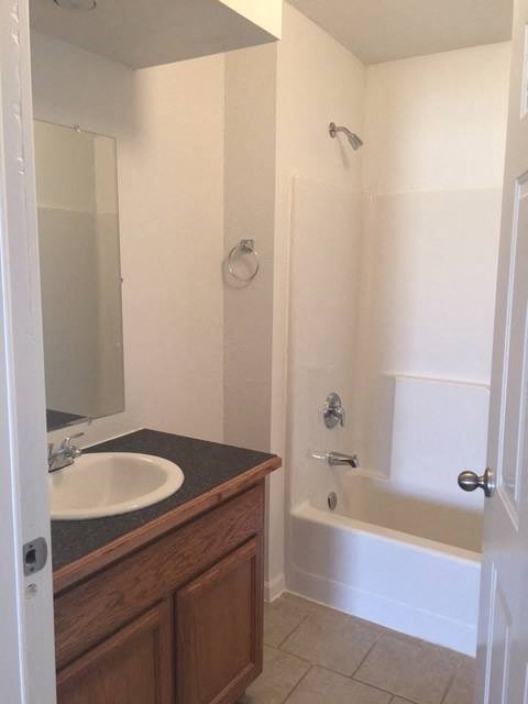 a white bathroom with a sink and a shower