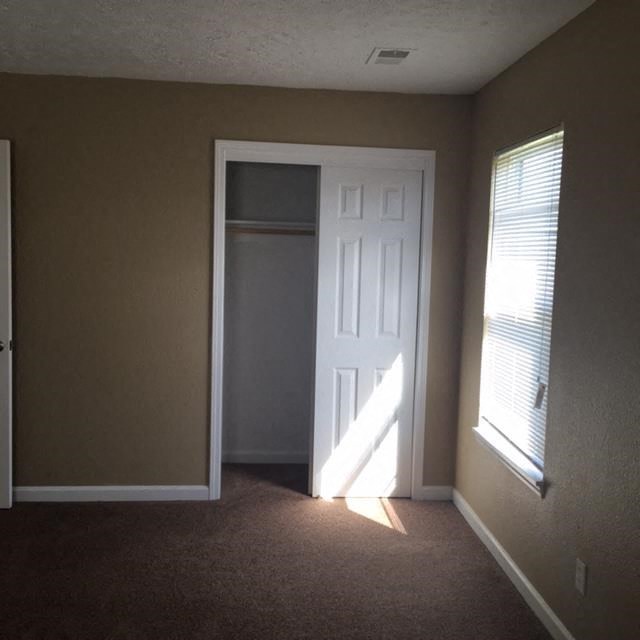 an empty room with a door and a closet