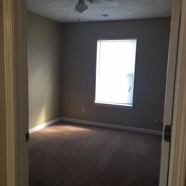 an empty room with a window and a door