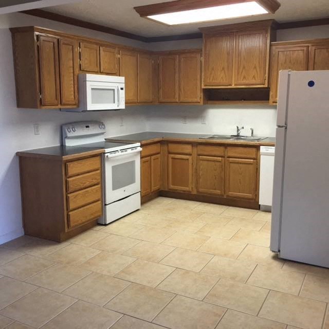 an empty kitchen with a stove and a refrigerator
