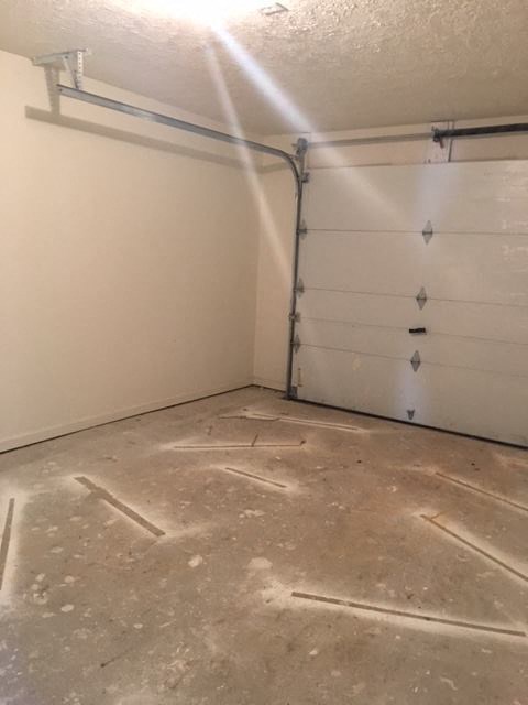 a garage with a white wall and a white garage door