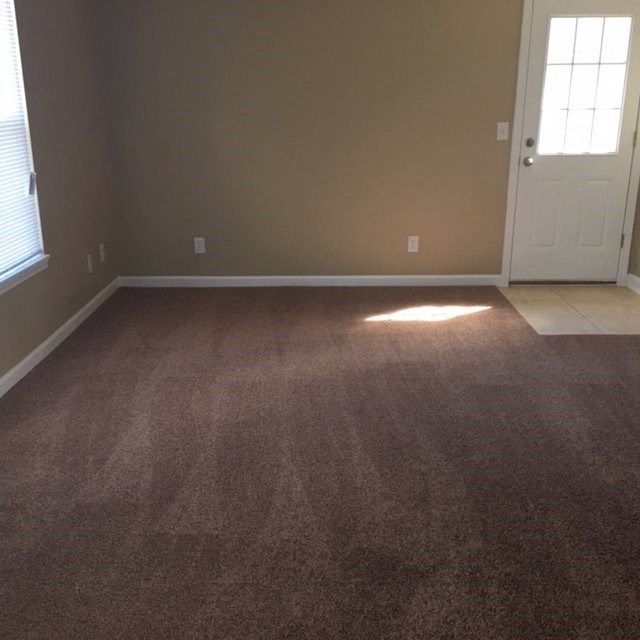 an empty room with a carpeted floor and a door