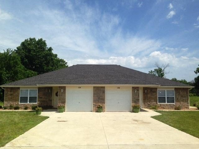 a brick house with two white garage doors