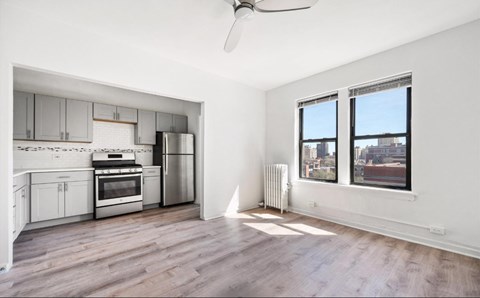A spacious kitchen with a refrigerator, oven, and cabinets.