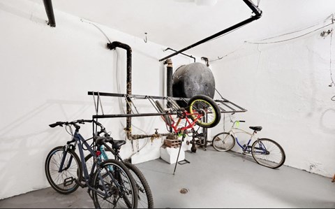 A bicycle repair shop with a variety of bikes and a large air pump.